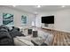 Inviting living area features a cozy gray sofa, stylish rug, and ample natural light at 13222 Fiore Pl, Huntersville, NC 28078