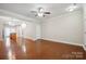 Bright living room showcasing hardwood floors, neutral walls, and an open layout to the kitchen and stairs at 13358 Calloway Glen Dr, Charlotte, NC 28273