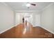 Open-concept living room with hardwood floors, ceiling fan, and seamless flow to the kitchen at 13358 Calloway Glen Dr, Charlotte, NC 28273