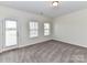 Bright bedroom featuring neutral carpet, white walls, and a door leading to the outside at 134 Kerri Dawn Ln # 117, Locust, NC 28097