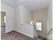 Upstairs hallway with neutral carpet leading to multiple rooms and a view of the stairs at 134 Kerri Dawn Ln # 117, Locust, NC 28097