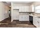 Modern kitchen features white cabinets, laminate flooring, and stainless steel appliances at 134 Kerri Dawn Ln # 117, Locust, NC 28097