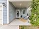 Cozy covered patio with seating, plants, and adjacent to the home's garage at 134 Kerri Dawn Ln # 117, Locust, NC 28097