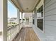 View of a covered porch with wood flooring, showcasing the neighborhood view at 134 Kerri Dawn Ln # 117, Locust, NC 28097