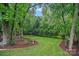 Serene backyard with a tree swing, firepit and mulched garden beds at 1402 Coachman Dr, Waxhaw, NC 28173