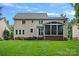Large backyard featuring a two-story house with a screened-in porch and a brick patio with seating at 1402 Coachman Dr, Waxhaw, NC 28173