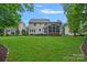 Expansive backyard featuring a two-story home with a charming screened-in porch and lush green lawn at 1402 Coachman Dr, Waxhaw, NC 28173