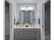 Bright bathroom featuring double sinks, light gray cabinets, and a large mirror reflecting a blue patterned shower curtain at 1402 Coachman Dr, Waxhaw, NC 28173