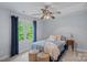 Cozy bedroom with a window overlooking the backyard, carpet, and a ceiling fan at 1402 Coachman Dr, Waxhaw, NC 28173