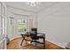 Bright home office with hardwood floors, bay window, and a modern black desk at 1402 Coachman Dr, Waxhaw, NC 28173