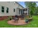 Charming brick patio featuring outdoor seating and a grill, surrounded by lush greenery and landscaping at 1402 Coachman Dr, Waxhaw, NC 28173