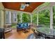 Inviting screened-in porch features comfortable seating, a ceiling fan, and a skylight offering a serene outdoor living space at 1402 Coachman Dr, Waxhaw, NC 28173