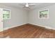 Bright bedroom featuring hardwood floors, neutral walls, two windows, and a ceiling fan at 2401 Wensley Dr, Charlotte, NC 28210