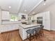 Bright, white kitchen features an island with barstools and stainless steel appliances at 2401 Wensley Dr, Charlotte, NC 28210