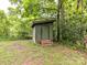 Backyard shows a green storage shed with wood stairs and dark trim, surrounded by grass, trees and a fence at 2401 Wensley Dr, Charlotte, NC 28210