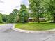 Property on a corner lot with lush landscaping, mature trees and a street sign at 2401 Wensley Dr, Charlotte, NC 28210