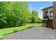 Spacious backyard with a stone patio, lush green lawn, mature trees, and access to the sunroom at 2606 Walker Rd, Matthews, NC 28105