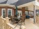 Spacious brick home back porch with a table and chairs, overlooking well landscaped backyard at 3115 Duck Point Dr, Monroe, NC 28110
