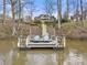 Dock with two chairs and kayak with long set of stairs leading up to a large brick home at 3115 Duck Point Dr, Monroe, NC 28110