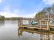 Floating dock on the water with two Adirondack chairs and a kayak with wooded area visible in background at 3115 Duck Point Dr, Monroe, NC 28110