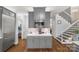 Kitchen island with stainless steel microwave and gray shaker cabinets adjoins a stairway at 3115 Duck Point Dr, Monroe, NC 28110