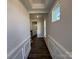 Bright hallway with detailed trim, dark wood floors, and a view into the bathroom at 4131 Black Ct # 170, Harrisburg, NC 28075