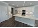 Bright kitchen featuring white cabinets, stainless steel appliances, and a large island with quartz countertops at 4131 Black Ct # 170, Harrisburg, NC 28075