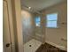 Walk-in shower featuring a glass door, marble-look tiling, a built-in bench, and a window for natural light at 4131 Black Ct # 170, Harrisburg, NC 28075
