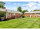 The backyard features a grassy area connecting two brick buildings, perfect for outdoor activities at 4226 Randolph Rd, Charlotte, NC 28211