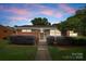Charming single-story home featuring a brick and stone facade with a well-manicured lawn and shrubs at 4226 Randolph Rd, Charlotte, NC 28211