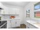 Well-lit kitchen featuring white cabinets, quartz countertops and stainless steel appliances with a view to the backyard at 4226 Randolph Rd, Charlotte, NC 28211
