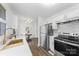 Open kitchen boasts stainless steel appliances, quartz countertops and a dining area with modern light fixture at 4226 Randolph Rd, Charlotte, NC 28211