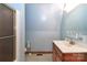 Bright bathroom features shower, wood cabinet sink, and a light blue wall at 443 Troutman Farm Rd, Statesville, NC 28677
