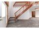 Bright entryway features plush gray carpet, a white front door, and an open wooden staircase at 443 Troutman Farm Rd, Statesville, NC 28677