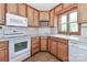 Cozy kitchen with wooden cabinets, white appliances, and plenty of counter space for meal preparation at 443 Troutman Farm Rd, Statesville, NC 28677