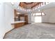 Open-concept living area with gray carpet and a combined kitchen featuring wood cabinets and white appliances at 443 Troutman Farm Rd, Statesville, NC 28677