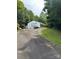 Large outbuilding, perfect for a workshop or storage, with ample driveway space and surrounded by trees at 443 Troutman Farm Rd, Statesville, NC 28677