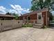 Cozy brick home featuring a covered patio and fenced yard, perfect for outdoor entertaining at 557 Melbourne Ct, Charlotte, NC 28209