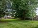 Expansive backyard featuring lush green grass, mature trees, and a charming decorative fence at 557 Melbourne Ct, Charlotte, NC 28209