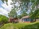 Spacious backyard featuring a covered patio, a detached garage, and a brick home at 557 Melbourne Ct, Charlotte, NC 28209