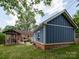 View of the backyard featuring a detached garage, a covered patio, and a brick home at 557 Melbourne Ct, Charlotte, NC 28209