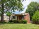 Quaint home featuring mixed siding, a cozy front porch, and vibrant landscaping at 557 Melbourne Ct, Charlotte, NC 28209
