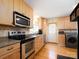 Well-equipped kitchen with a modern stove, stainless steel appliances, ample counter space, and natural wood cabinetry at 557 Melbourne Ct, Charlotte, NC 28209