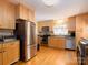 Bright kitchen boasts stainless steel appliances, granite countertops, wooden cabinets and hardwood floors at 557 Melbourne Ct, Charlotte, NC 28209