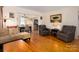 Inviting living room featuring hardwood floors, comfortable seating, and seamlessly connected dining and kitchen areas at 557 Melbourne Ct, Charlotte, NC 28209