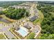 Aerial view of community pool, clubhouse and neighborhood pond surrounded by lush trees at 5625 Axil Ln, Charlotte, NC 28269