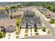 Aerial view of gray and tan townhouse community with manicured lawns, sidewalks and neighborhood street at 5625 Axil Ln, Charlotte, NC 28269