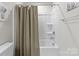 Clean bathroom with a white tub and shower featuring a beige shower curtain at 5625 Axil Ln, Charlotte, NC 28269