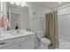 Well-lit bathroom with a vanity, toilet, tub, and shower with a beige curtain at 5625 Axil Ln, Charlotte, NC 28269
