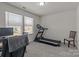 Bedroom with neutral walls and carpet, two windows, desk, and chair, with an exercise machine at 5625 Axil Ln, Charlotte, NC 28269